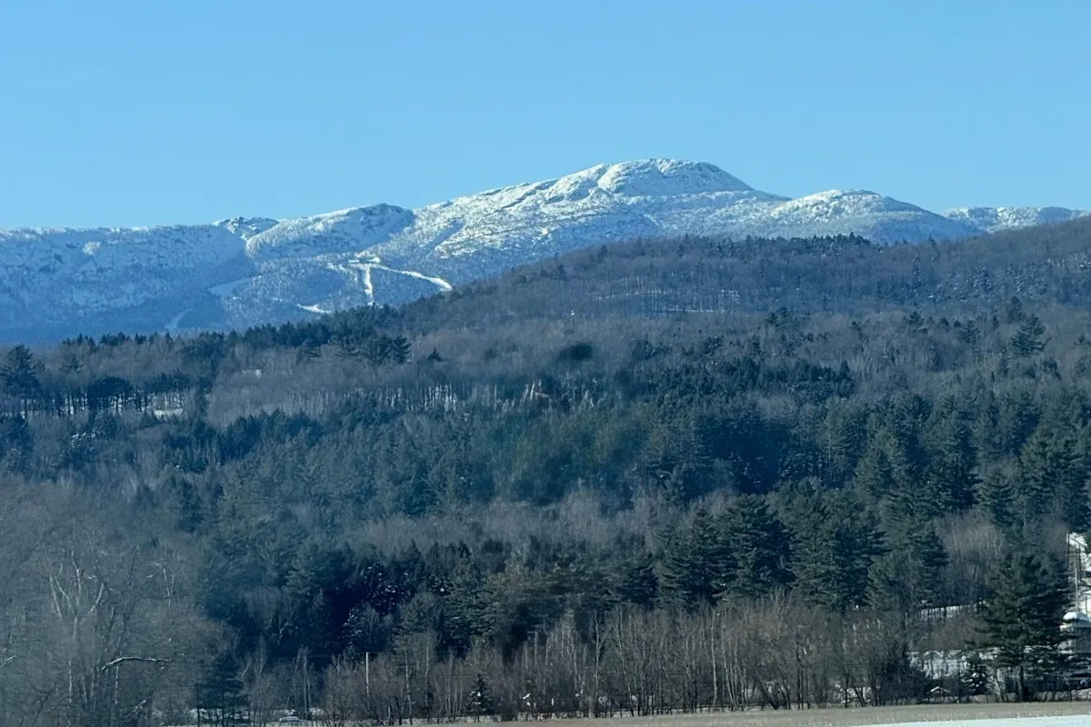 Mount Mansfield seen across a snowy field in Stowe